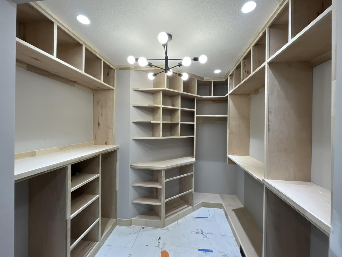 Custom walk-in closet shelving and storage system built by Ruach Custom Carpentry in Columbus, Ohio, featuring handcrafted open shelving, custom shoe racks, and built-in storage compartments designed for maximum organization and style. This luxury closet project showcases expert finish carpentry, custom woodwork, and precision craftsmanship, creating a beautiful and functional walk-in closet space for a high-end Central Ohio home.