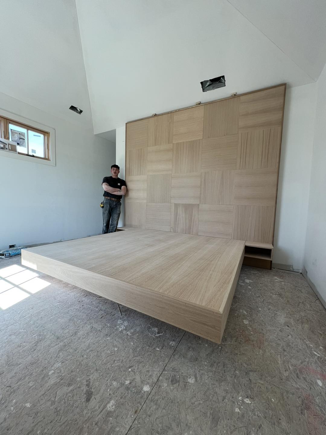 Custom floating platform bed with integrated floating nightstand shelves and a large decorative wood feature wall, built by Ruach Custom Carpentry in Columbus, Ohio. This project features handcrafted natural wood paneling, modern seamless design, and precision finish carpentry. Highlighting expert custom furniture building, floating woodwork design, and luxury architectural craftsmanship, this project transforms a primary bedroom into a modern, high-end retreat in a Central Ohio home.