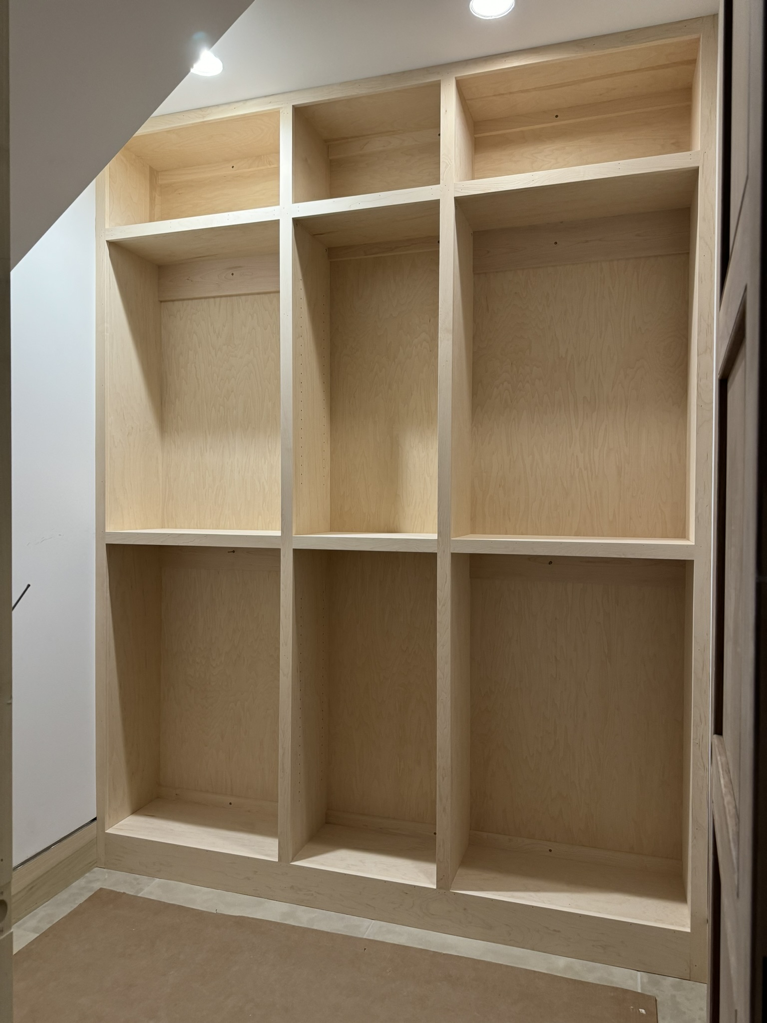 Custom built-in shelving unit handcrafted by Ruach Custom Carpentry, designed to maximize storage space under a staircase. Featuring precision carpentry with clean lines, adjustable shelving, and a natural wood finish, this built-in is perfect for closets, mudrooms, or organizational spaces. Expertly crafted in Columbus, Ohio to add both functionality and beauty to luxury homes.