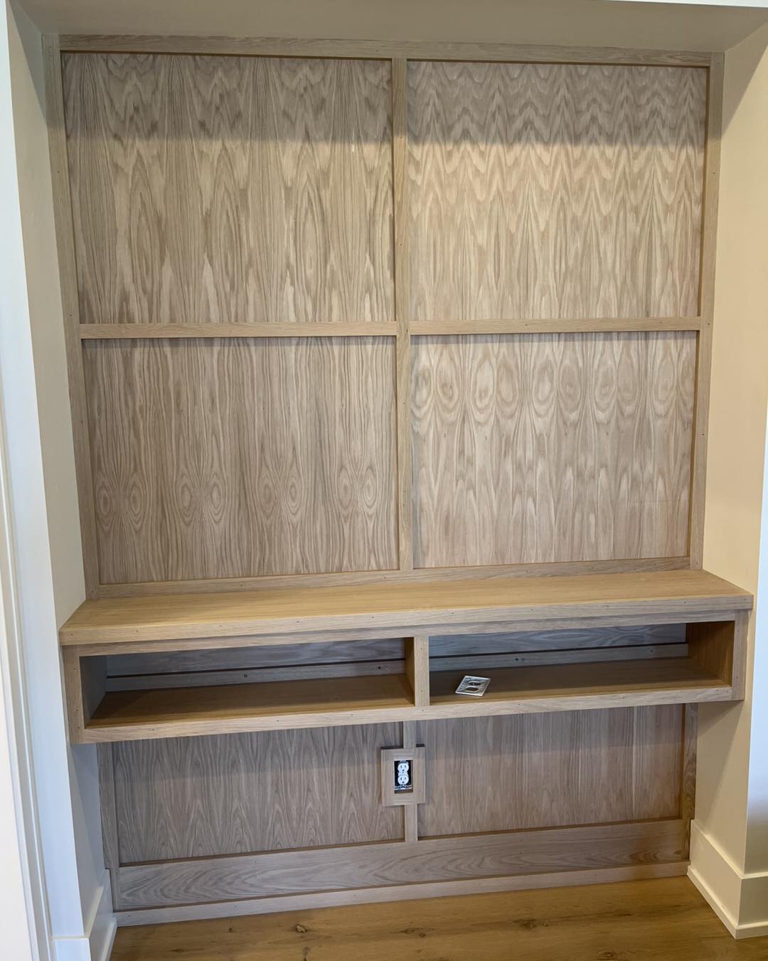 Custom wall paneling and built-in shelving unit crafted by Ruach Custom Carpentry in Columbus, Ohio, featuring natural wood panel details and handcrafted open shelving designed for media, décor, and storage solutions. This finish carpentry project showcases expert craftsmanship, custom woodwork, and precision trim installation, enhancing the functionality and aesthetic of a modern residential living space in Central Ohio.