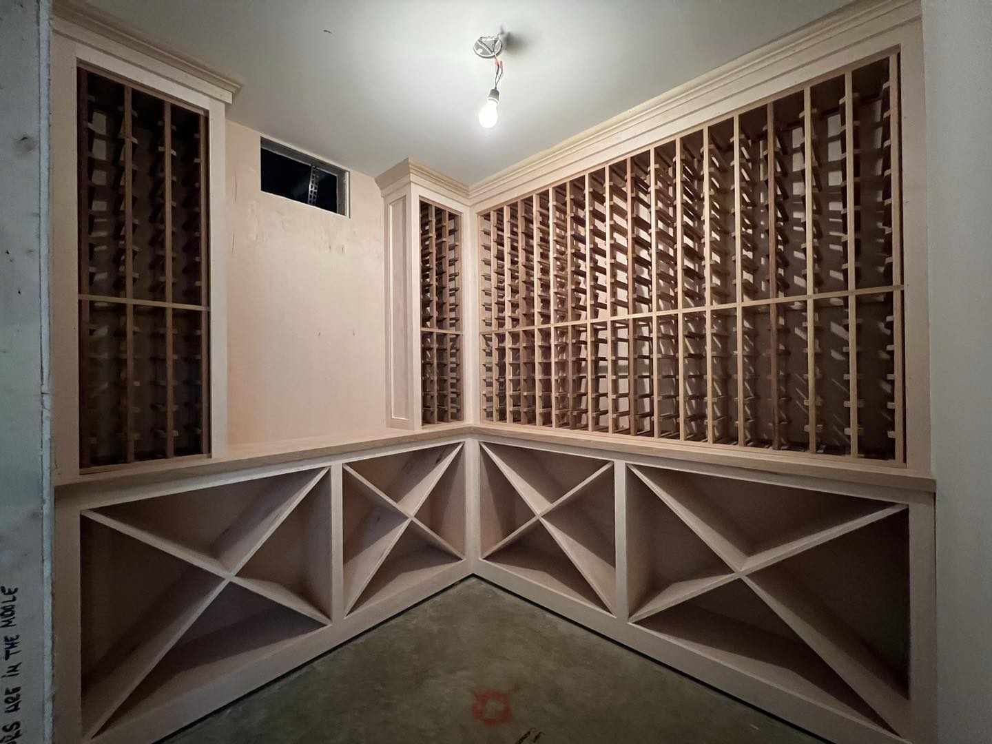 Custom-built wood wine cellar shelving system crafted by Ruach Custom Carpentry in Columbus, Ohio, featuring detailed finish carpentry, handcrafted bottle racks, and custom X-bin storage design for optimal wine organization. This custom woodwork project highlights precision craftsmanship, high-end residential carpentry, and custom storage solutions for luxury homes in Central Ohio.